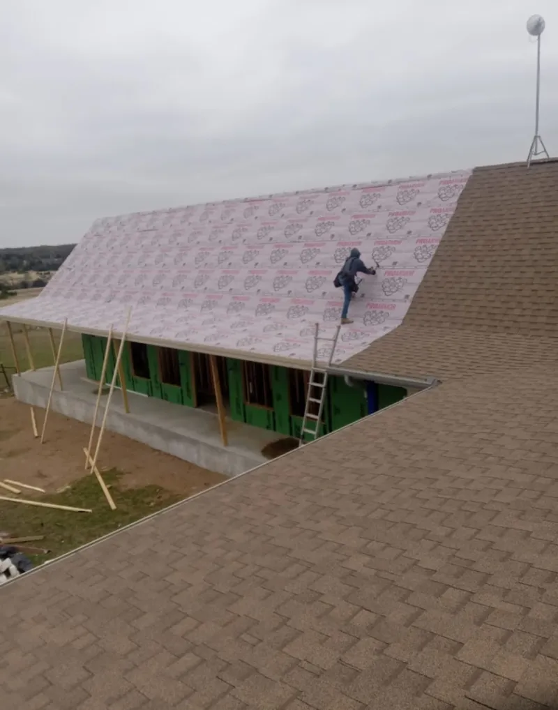 Worker preparing underlayment for a metal roof installation in Port LaBelle